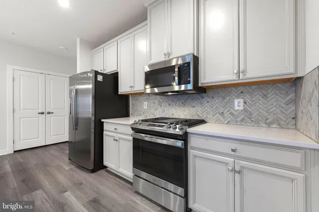 a kitchen with stove and wooden floor