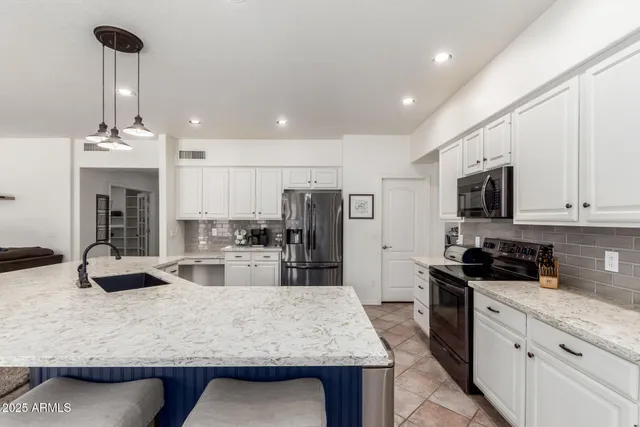 a kitchen with stainless steel appliances granite countertop a sink counter space and cabinets