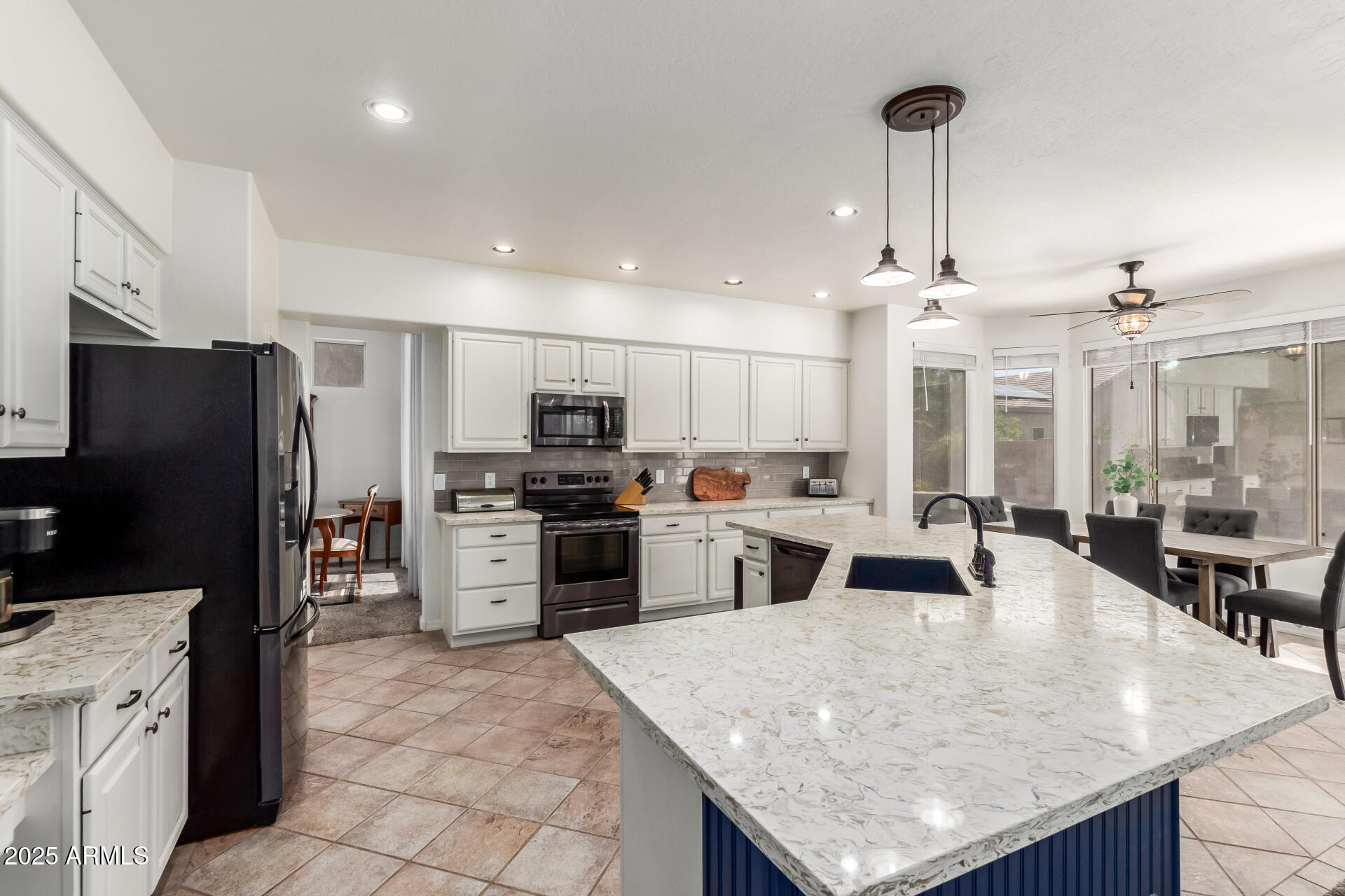 2859 East Millbrae Lane Gilbert, AZ 85234 - Photo 12 of 42 a kitchen with stainless steel appliances kitchen island granite countertop a stove refrigerator and cabinets