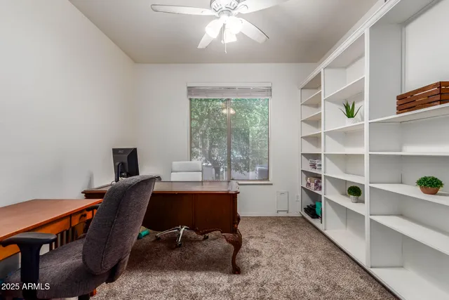 a view of a workspace with furniture and a window