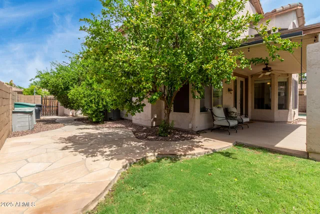 a view of a house with backyard and tree