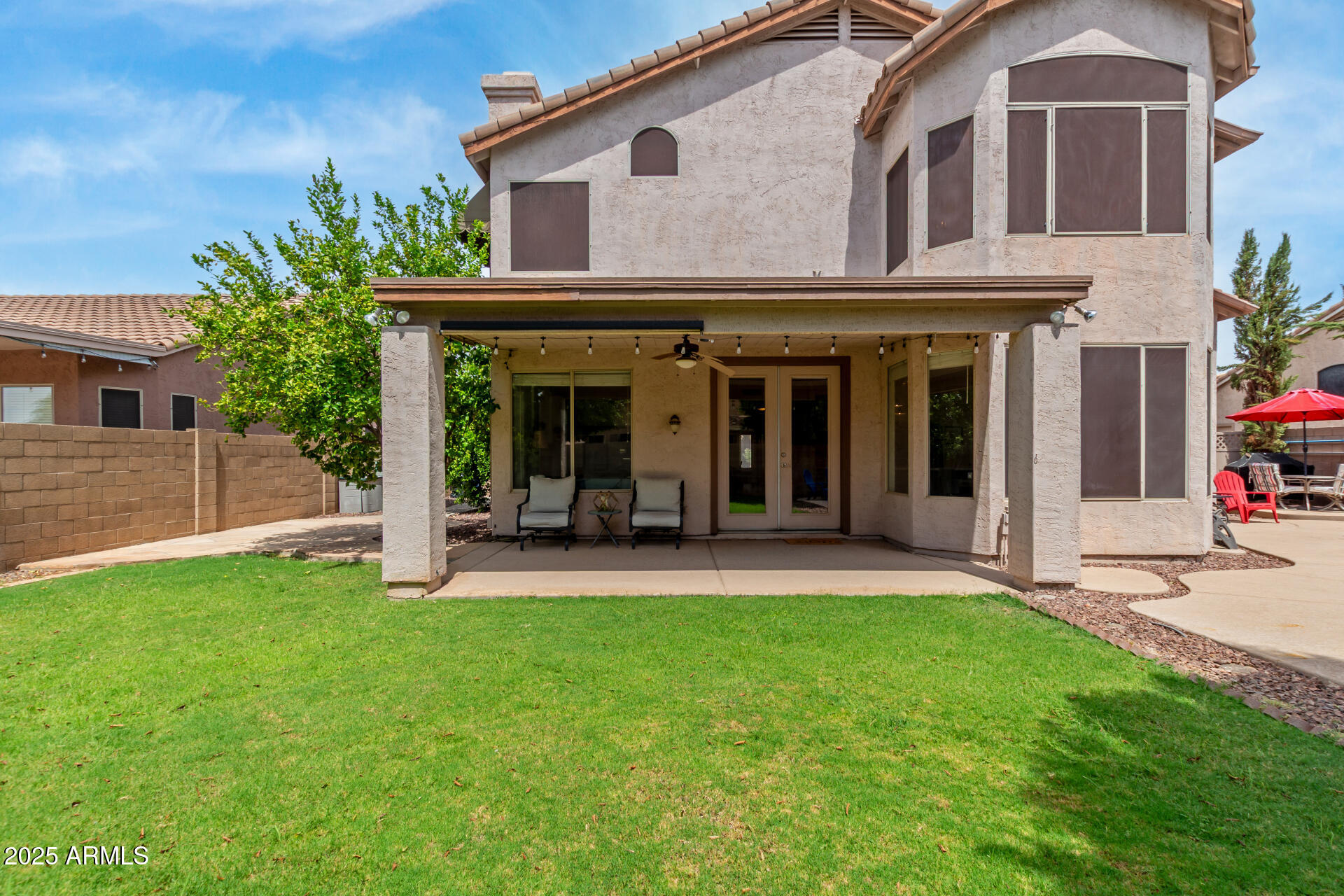 2859 East Millbrae Lane Gilbert, AZ 85234 - Photo 42 of 42 a view of a white house with a large window and a yard