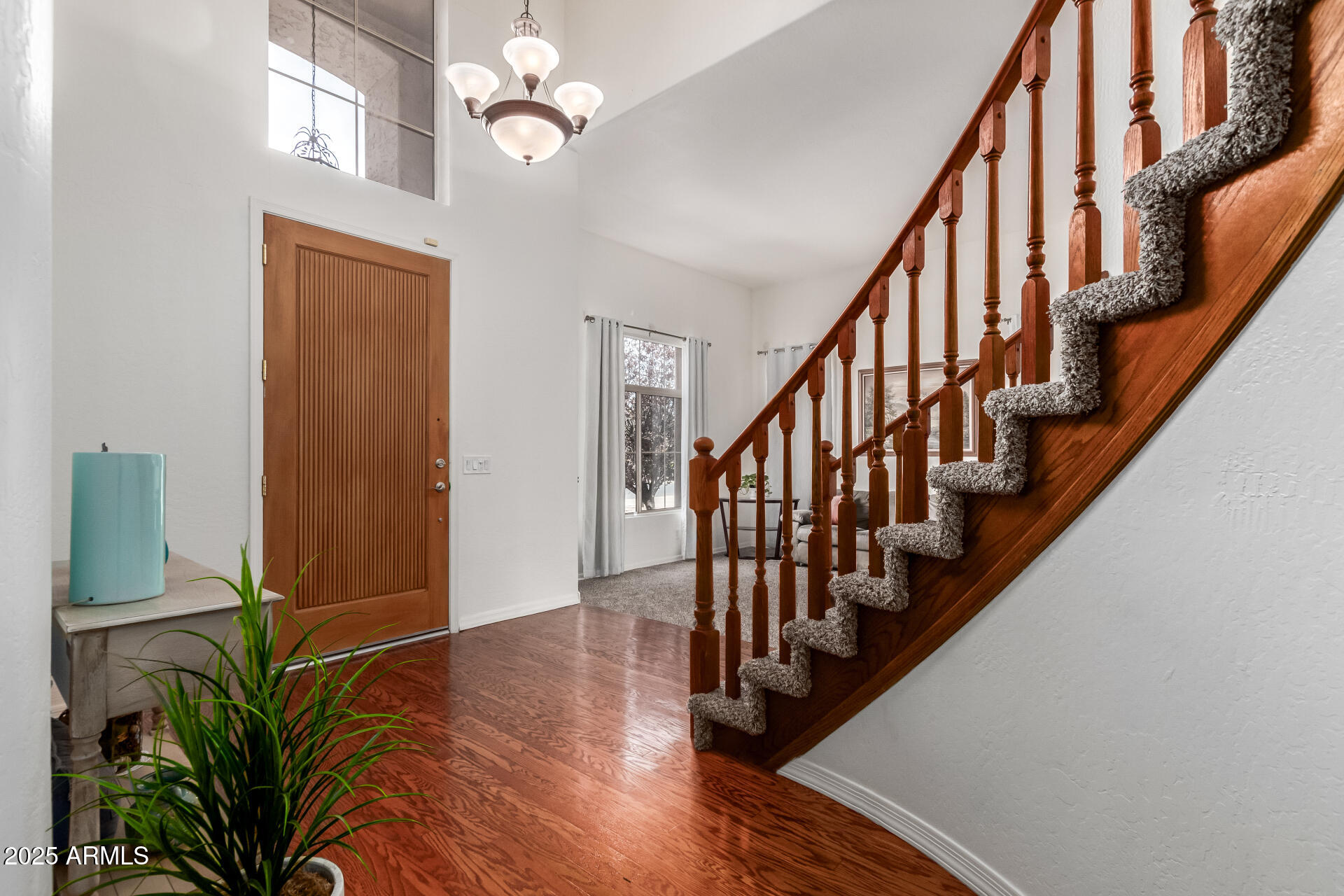 2859 East Millbrae Lane Gilbert, AZ 85234 - Photo 6 of 42 a view of staircase with wooden floor and a chandelier