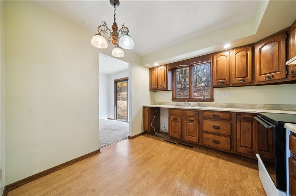 6149 Baker School Road Trafford, PA 15085 - Photo 9 of 30 a kitchen with stainless steel appliances granite countertop a stove a sink dishwasher and a microwave oven with cabinets