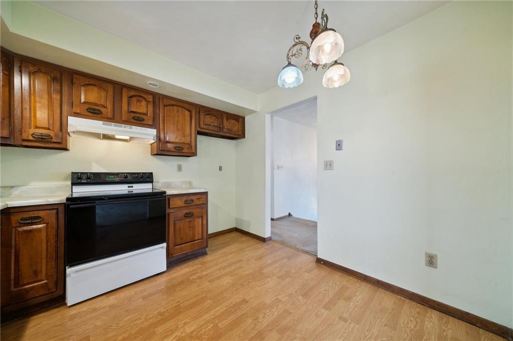 6149 Baker School Road Trafford, PA 15085 - Photo 10 of 30 a kitchen with stainless steel appliances granite countertop a stove a sink dishwasher and a microwave oven with white cabinets