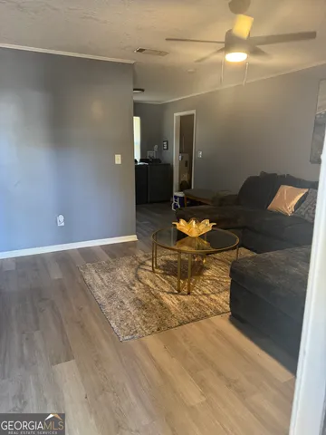a living room with furniture and wooden floor