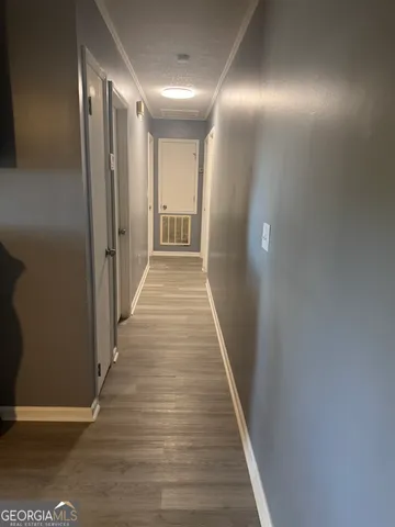 a view of a hallway with wooden floor