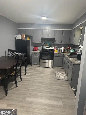 a kitchen with a wooden floor and chairs