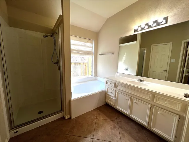 a bathroom with a tub sink and mirror