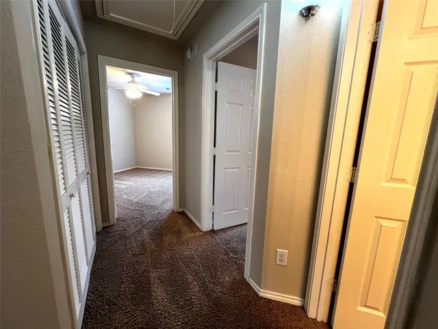a view of a hallway with wooden floor and a door