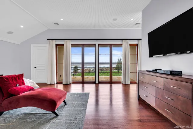 a spacious bedroom with a bed and a flat screen tv