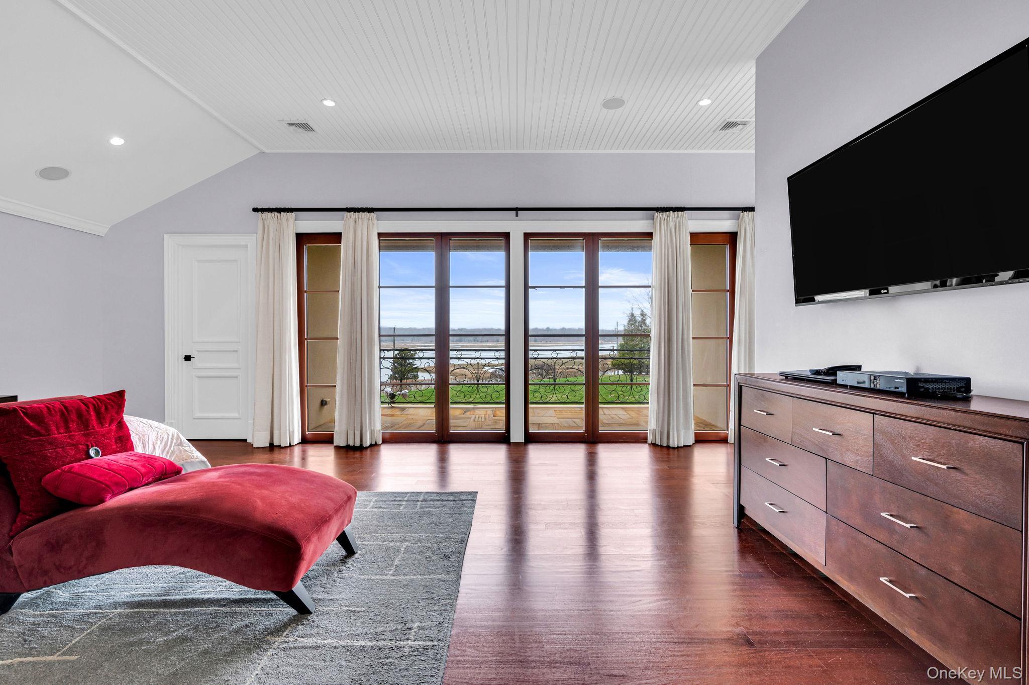 717 Short Beach Road St. James, NY 11780 - Photo 20 of 47 a spacious bedroom with a bed and a flat screen tv