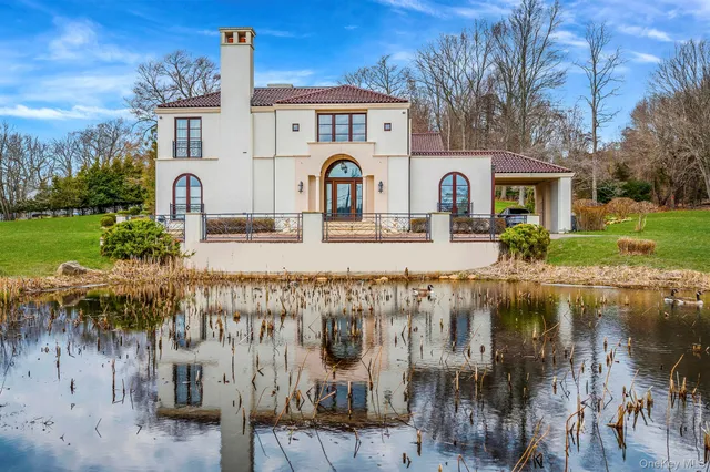 a front view of a house with garden and lake view