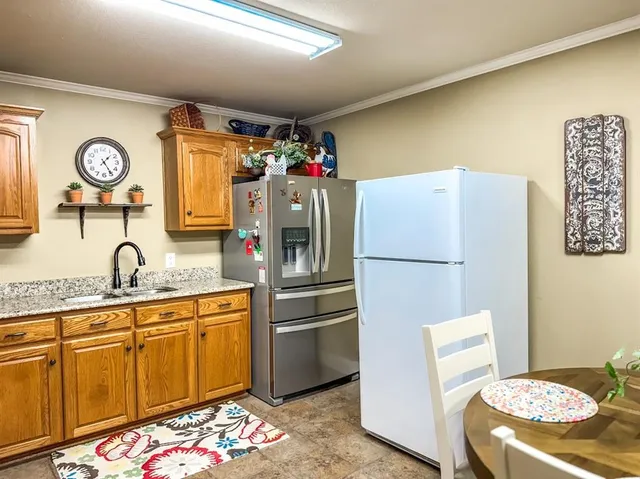 a kitchen with stainless steel appliances granite countertop a refrigerator sink and stove