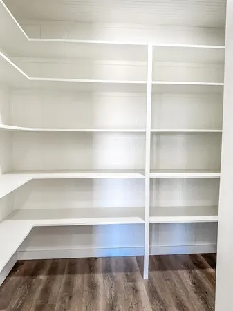 a view of walk in closet with empty racks