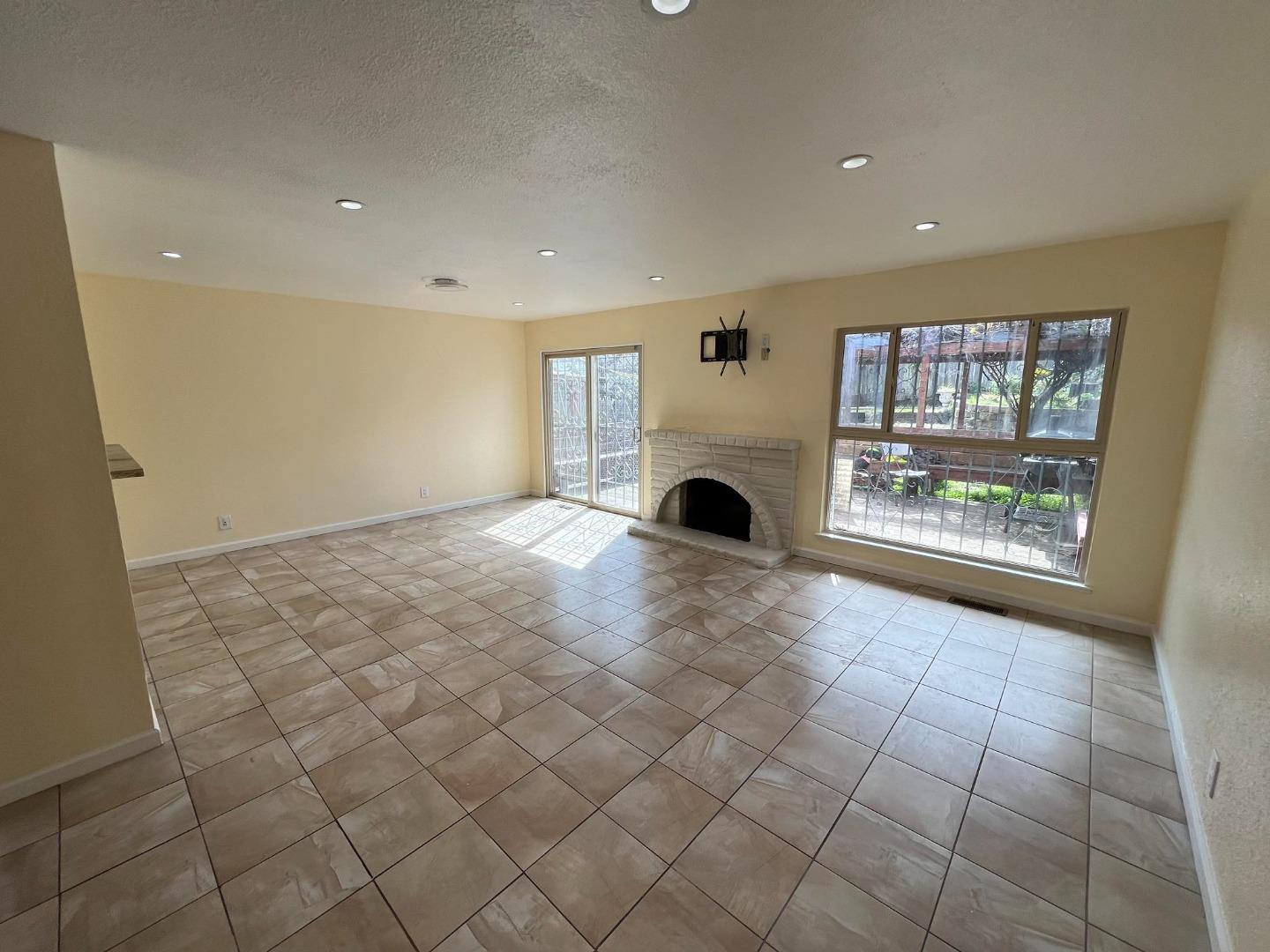 an empty room with windows and fireplace