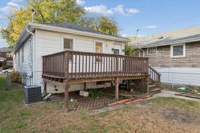 a view of a house with a yard and wooden deck