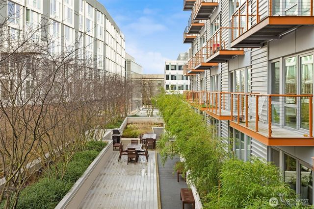 a balcony with chairs and table with wooden floor and fence