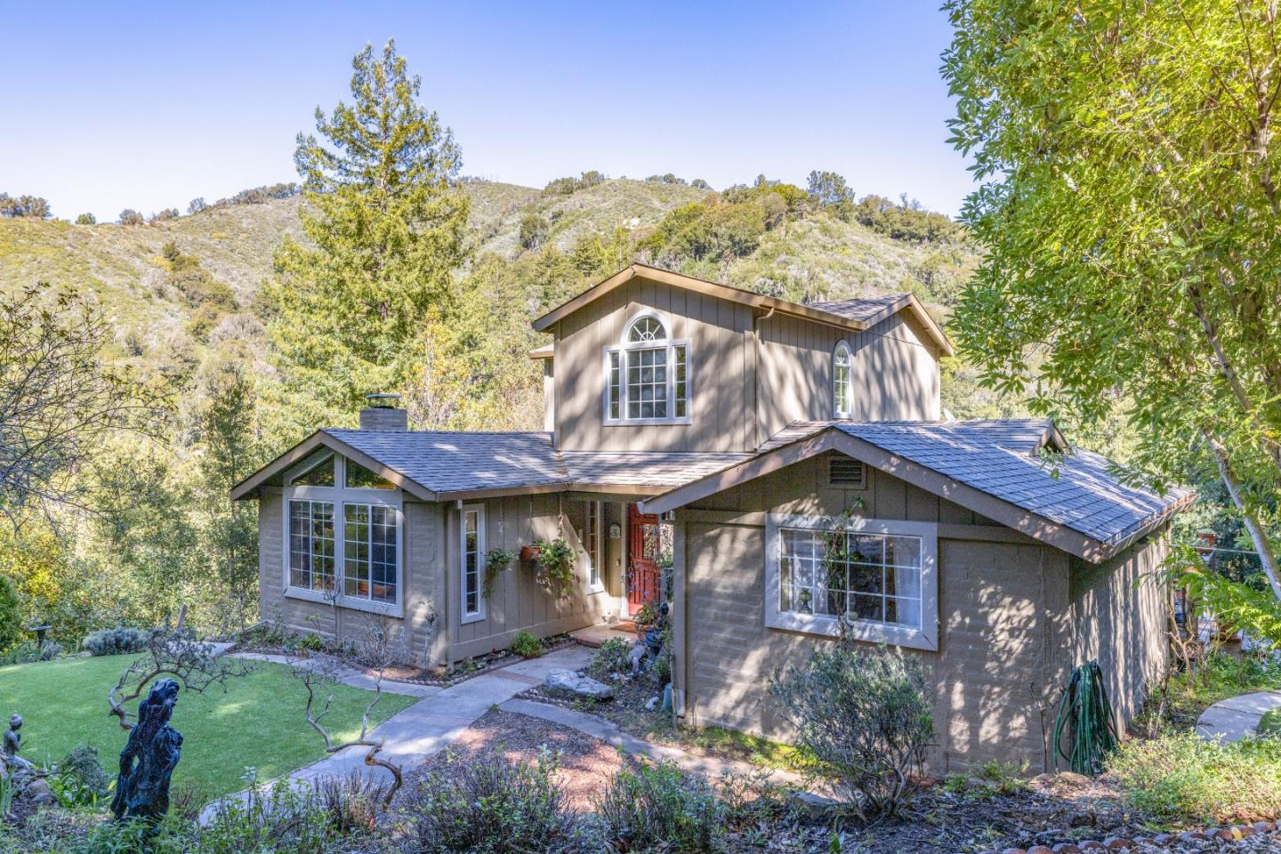 38621 Palo Colorado Road Carmel, CA 93923 - Photo 3 of 32 a front view of a house with a yard and mountain view in back