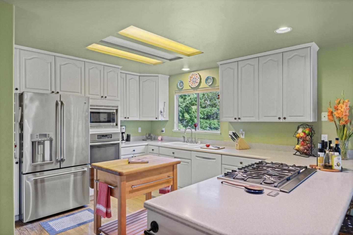 38621 Palo Colorado Road Carmel, CA 93923 - Photo 10 of 32 a kitchen with a sink a stove a refrigerator cabinets and a window