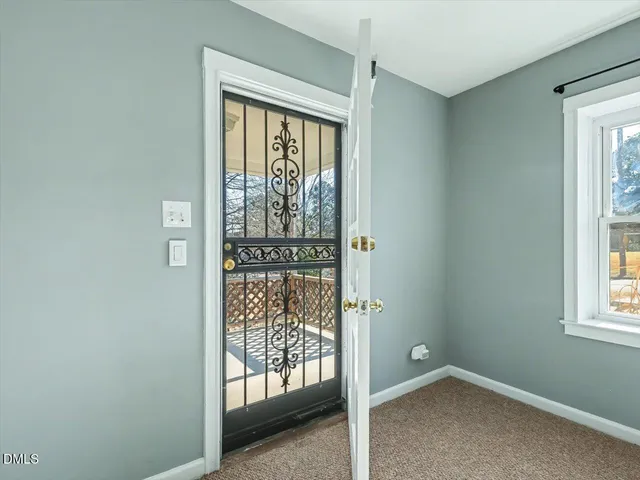 an empty room with windows and ceiling fan