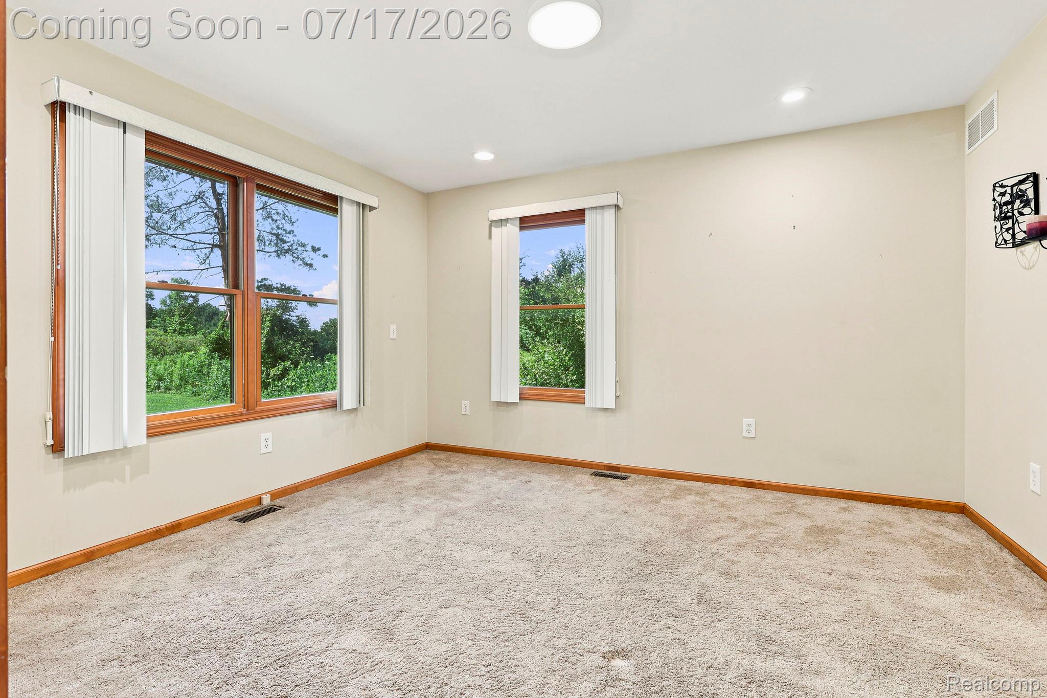 9805 Dolan Road Columbus, MI 48063 - Photo 24 of 39 Spacious room featuring multiple windows with wood trim, neutral carpeting, recessed lighting, and a flush-mount ceiling light