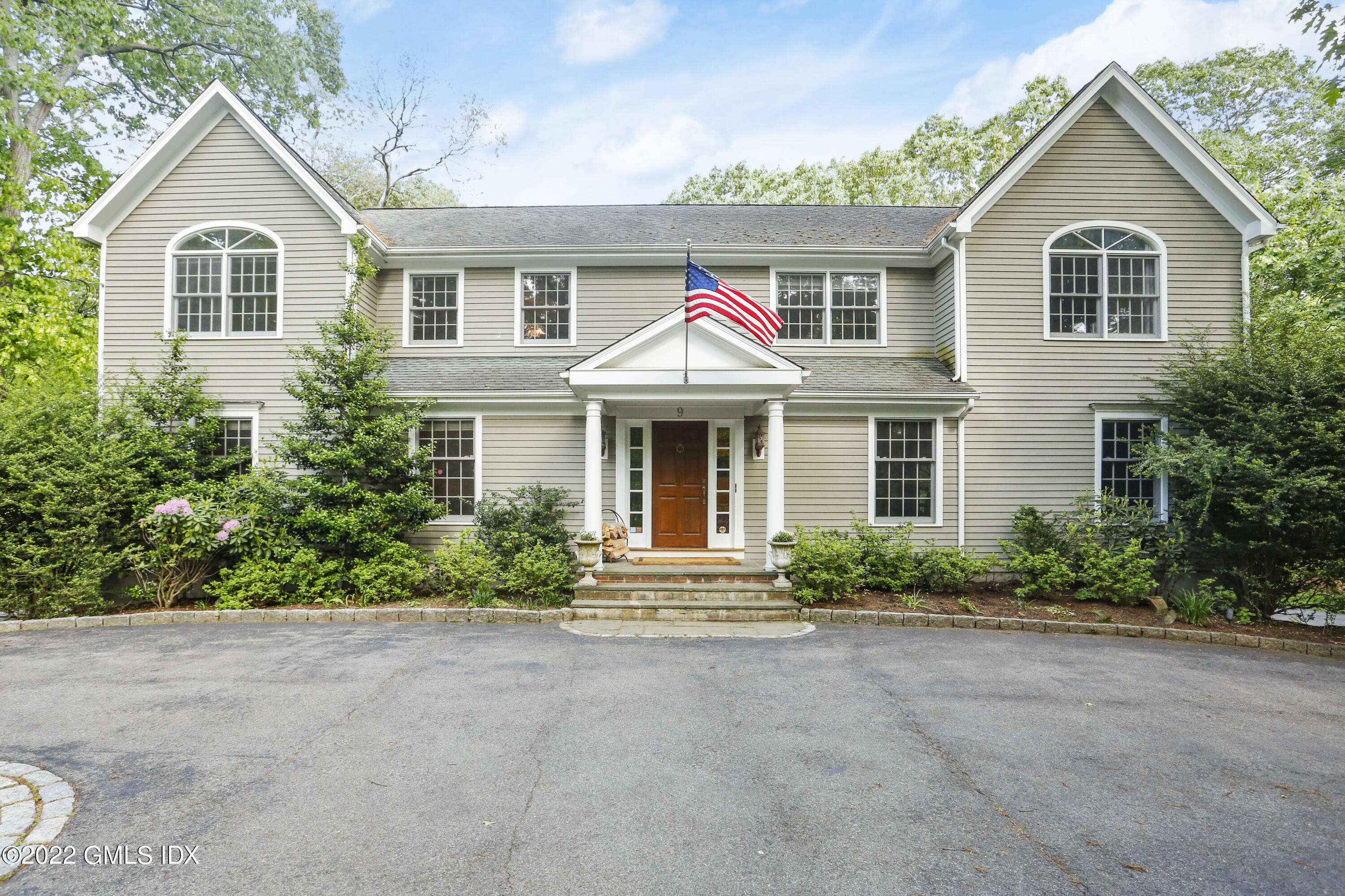 9 Frontier Road Cos Cob, CT 06807 - Photo 1 of 37 a front view of a house with a yard and garage