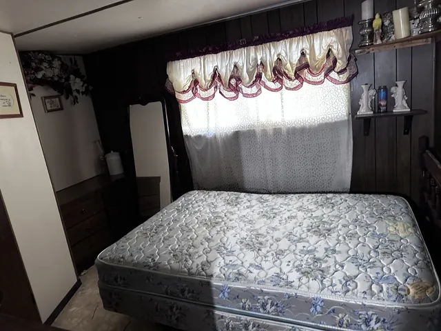 a bed sitting in a bedroom next to a window