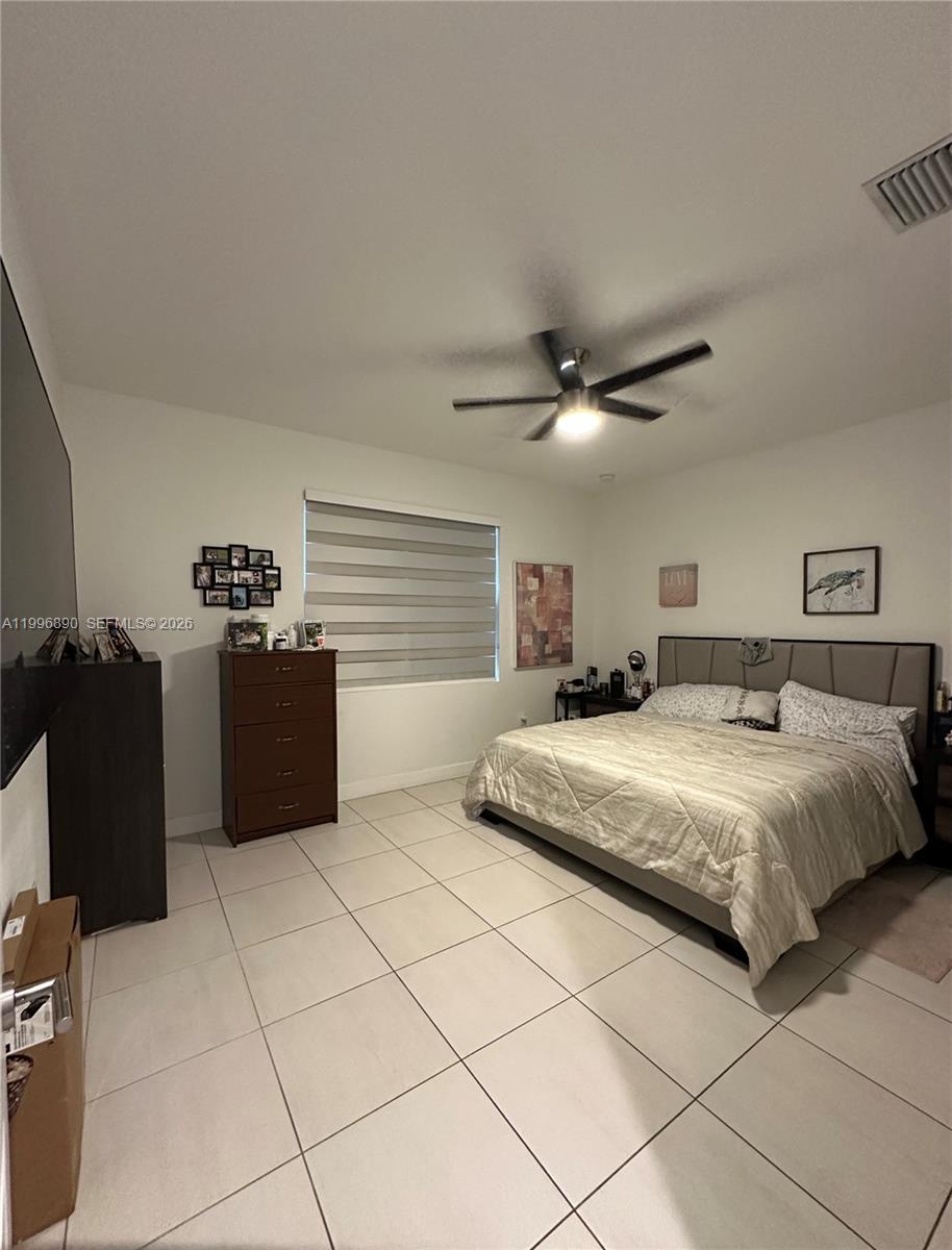 23552 Southwest 107th Place Homestead, FL 33032 - Photo 22 of 30 a bedroom with a bed and dresser