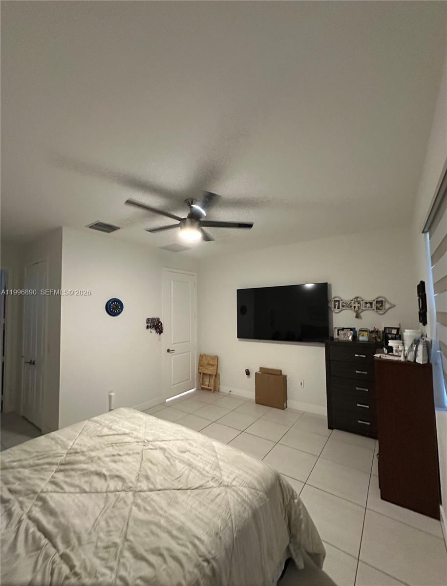 23552 Southwest 107th Place Homestead, FL 33032 - Photo 23 of 30 a bedroom with a bed and a flat tv screen on dresser