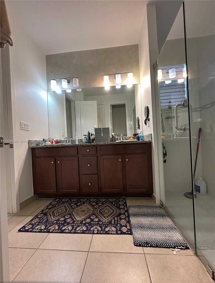 23552 Southwest 107th Place Homestead, FL 33032 - Photo 26 of 30 a bathroom with a sink a large mirror and a shower