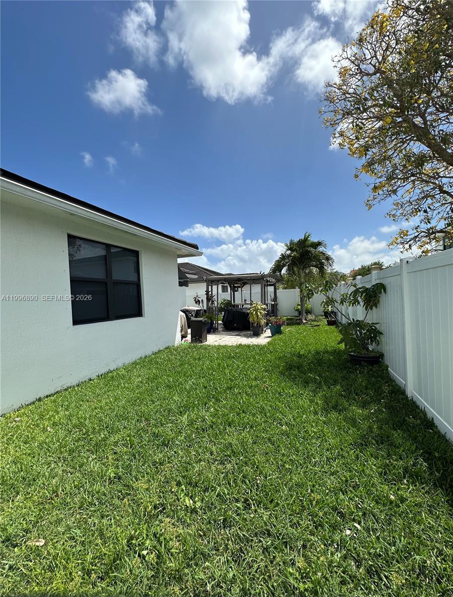 23552 Southwest 107th Place Homestead, FL 33032 - Photo 30 of 30 a front view of a house with garden