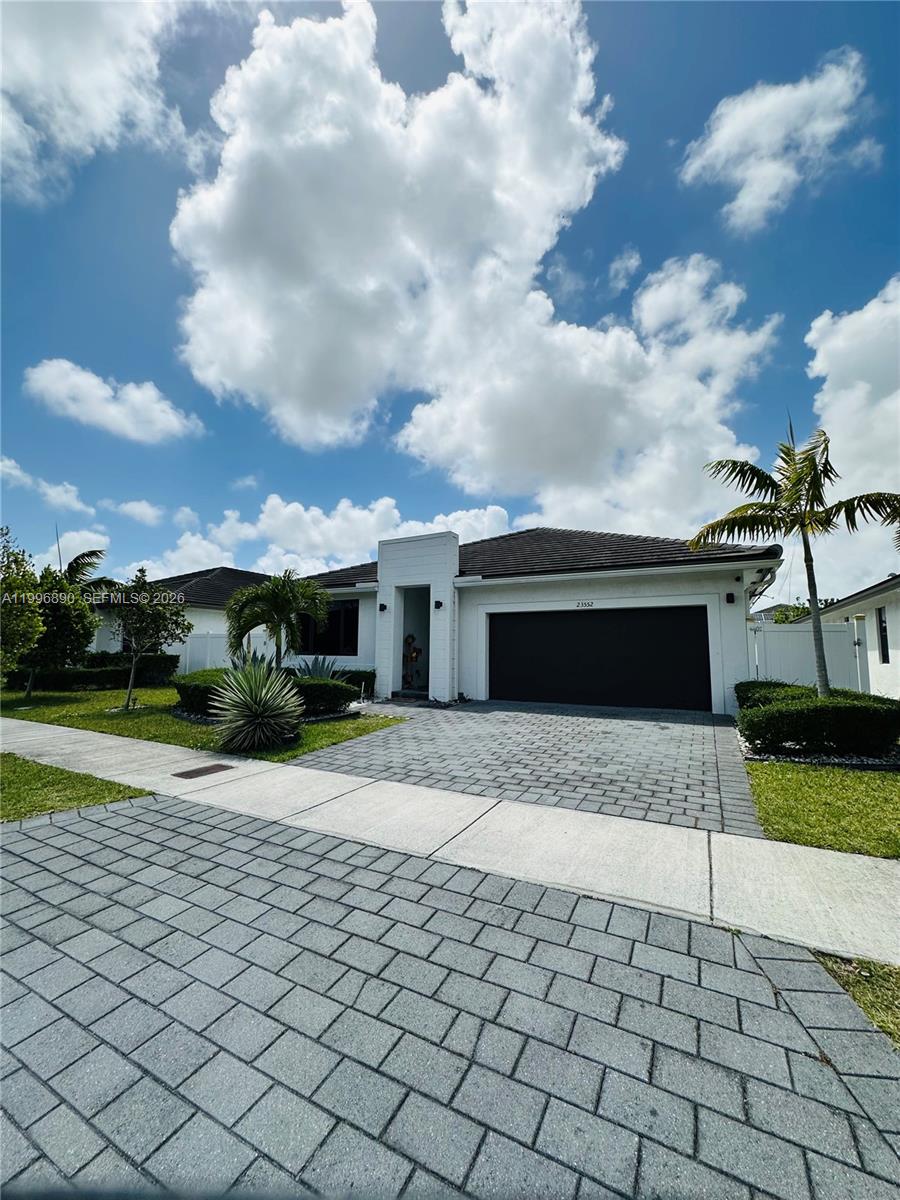 23552 Southwest 107th Place Homestead, FL 33032 - Photo 6 of 30 a front view of a house with a yard and garage