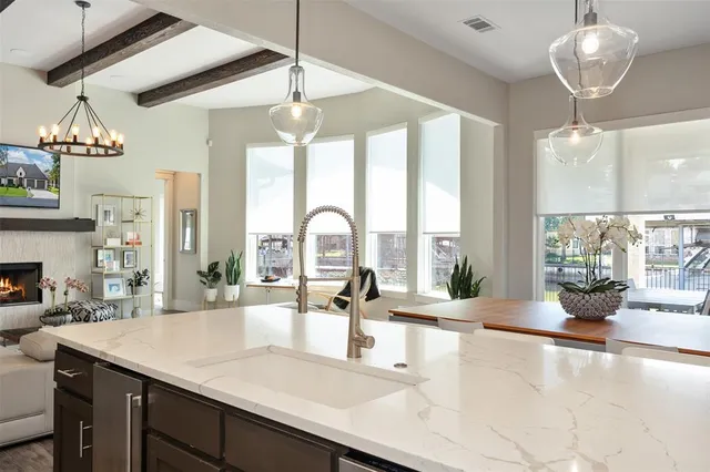 a kitchen with a counter space a sink and living room view
