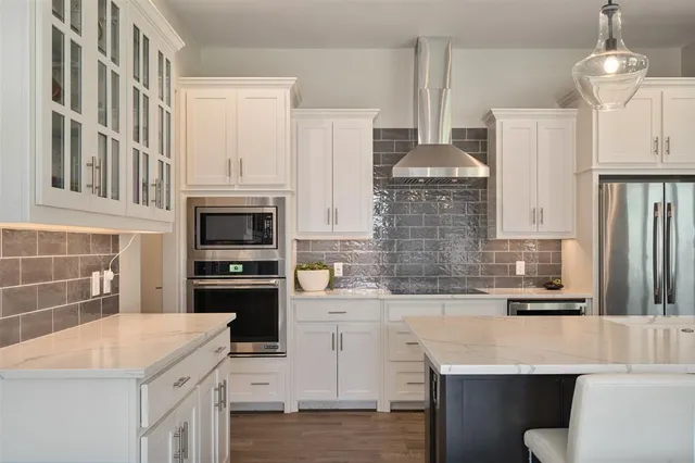 a kitchen with stainless steel appliances kitchen island granite countertop a stove a sink and a refrigerator