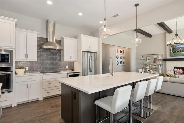 a kitchen with a dining table chairs stainless steel appliances and cabinets