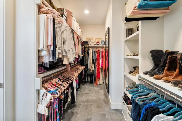 a view of walk in closet with clothes and shoes
