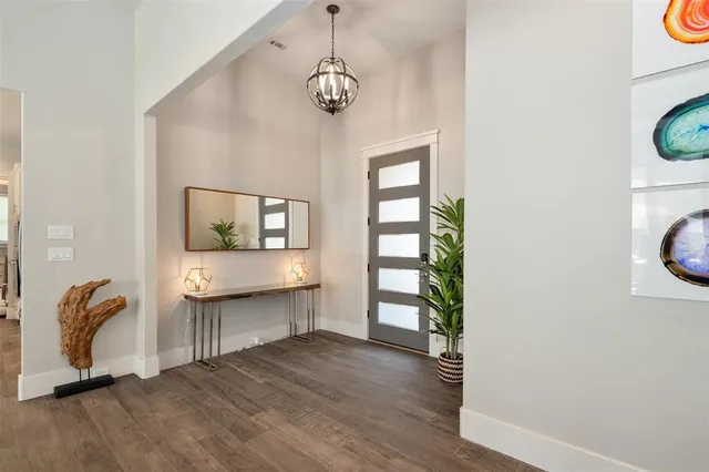 a view of a hallway with wooden floor and a window