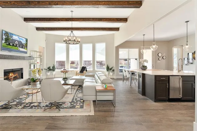 a living room with furniture a fireplace and a chandelier
