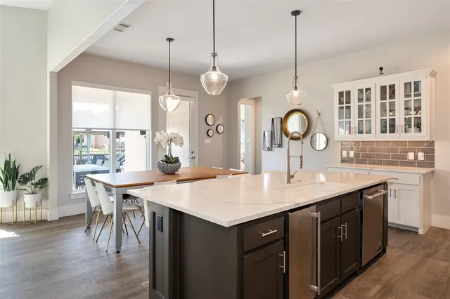a kitchen with a table a sink and cabinets