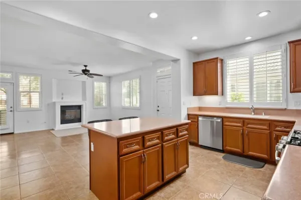 a large kitchen with kitchen island granite countertop a stove a sink a window and dining table