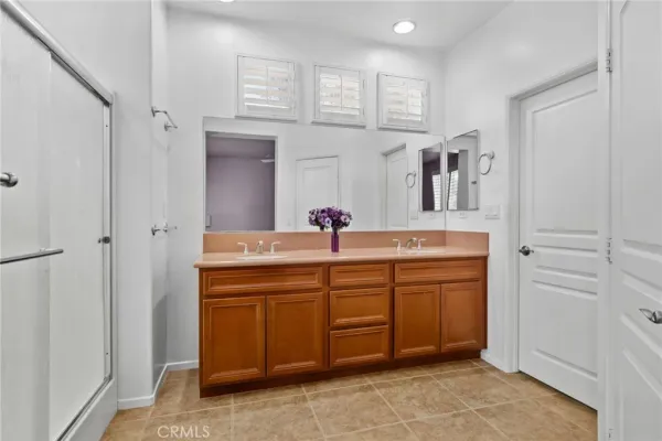 a bathroom with a granite countertop shower a sink and mirror