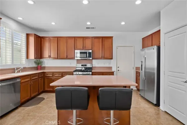 a kitchen with granite countertop a refrigerator stove microwave and sink