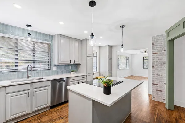 a kitchen with a sink a counter space appliances and cabinets