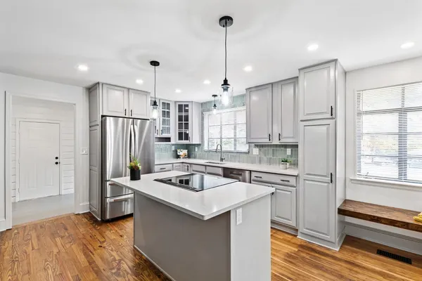 a kitchen that has a lot of cabinets a sink and appliances in it