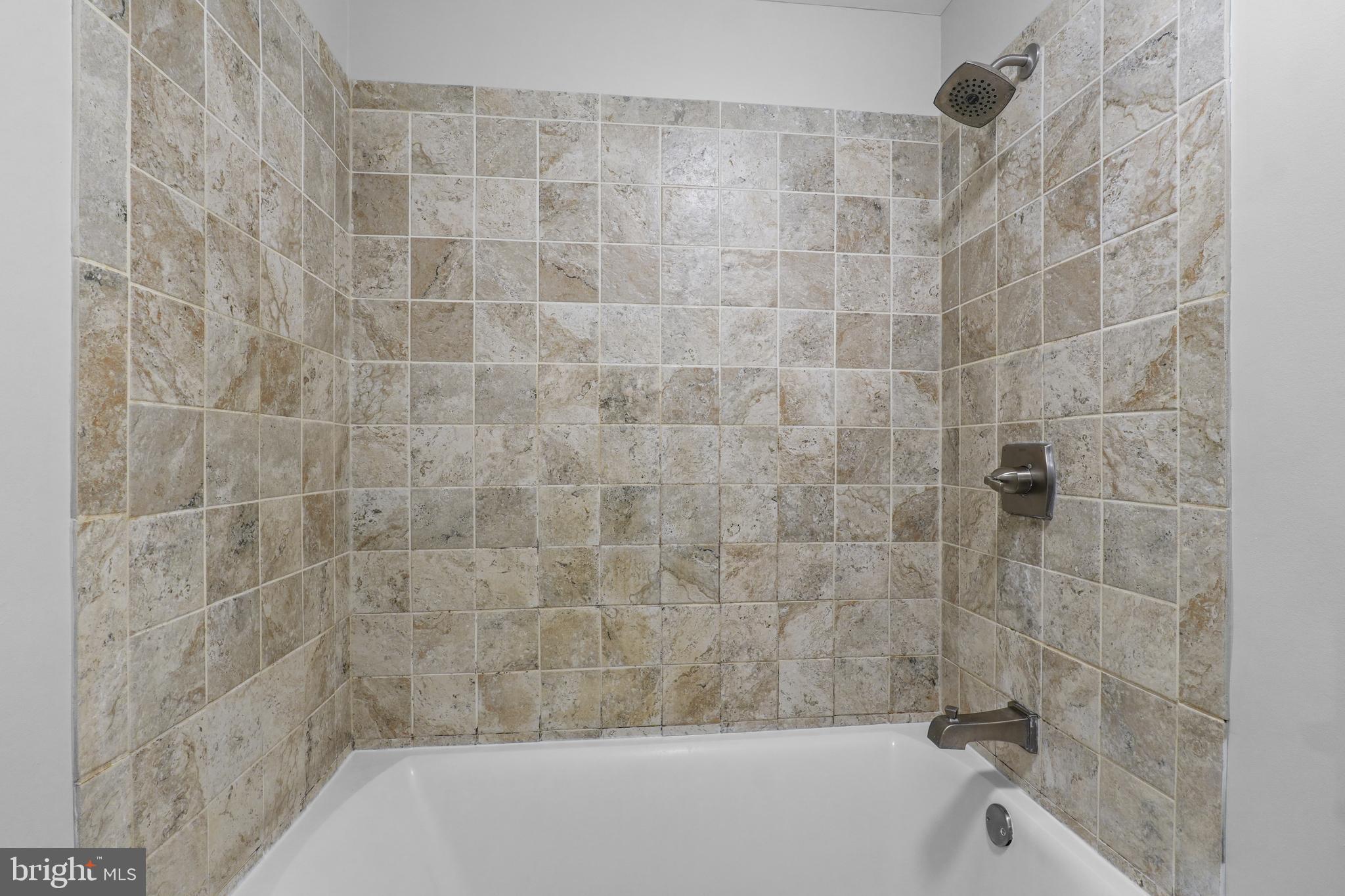 8729 Ritchboro Road District Heights, MD 20747 - Photo 14 of 22 a bathroom with a bathtub and a shower