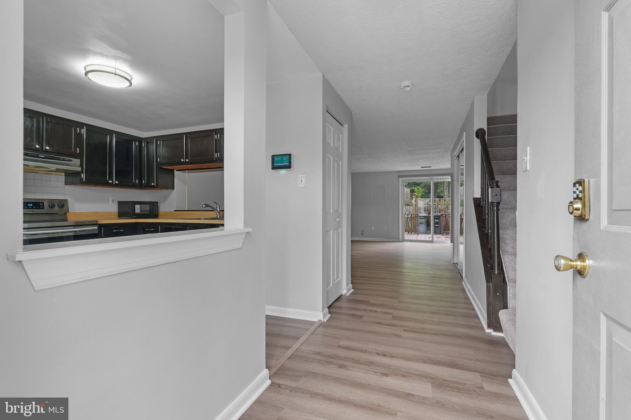 8729 Ritchboro Road District Heights, MD 20747 - Photo 3 of 22 a hallway with wooden floor and a refrigerator