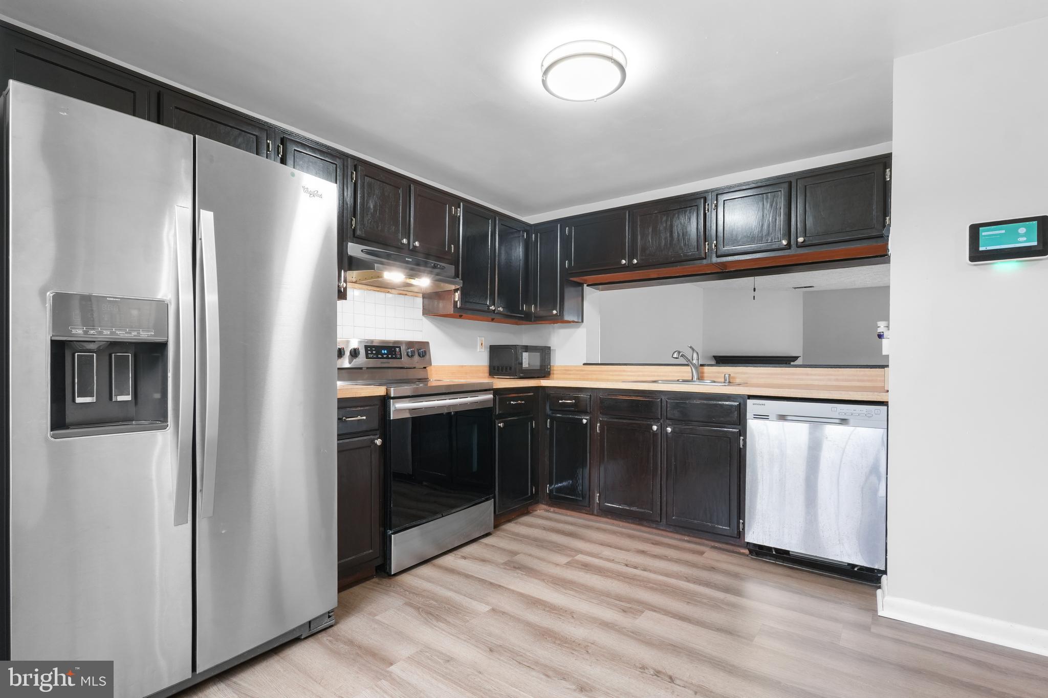 8729 Ritchboro Road District Heights, MD 20747 - Photo 4 of 22 a kitchen with stainless steel appliances granite countertop a refrigerator a sink a stove and oven