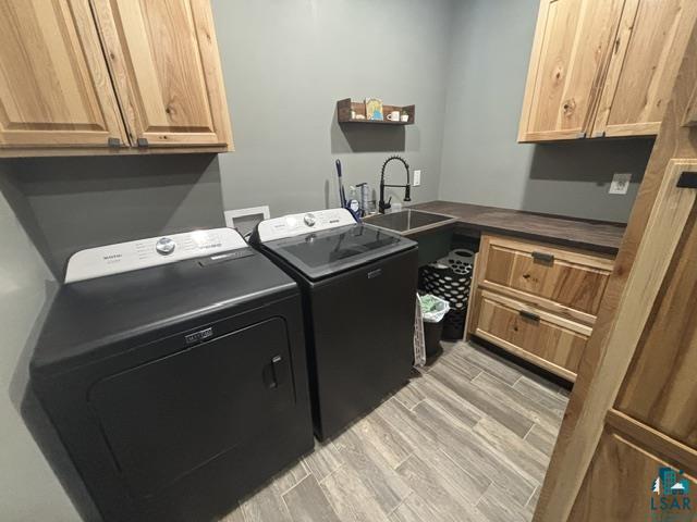 3454 Anderson Road Hibbing, MN 55746 - Photo 18 of 31 Dedicated laundry space featuring wood-finish cabinetry, a utility sink with a gooseneck faucet, a substantial countertop, and wood-finish flooring