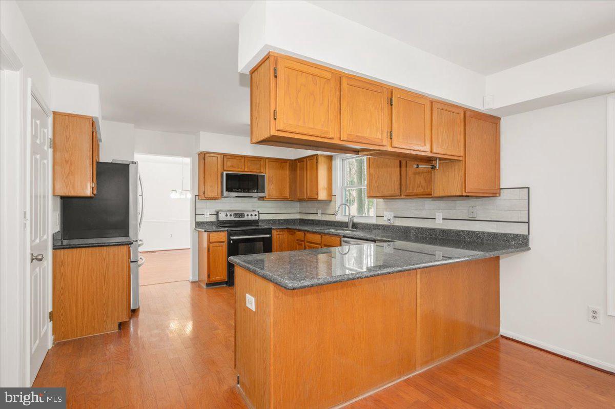 1404 Partridge Lane Bowie, MD 20721 - Photo 19 of 78 a kitchen with stainless steel appliances granite countertop a sink stove and refrigerator